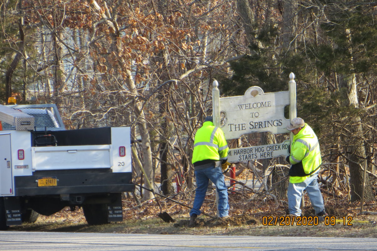 Town workers removing the The Spring sign
