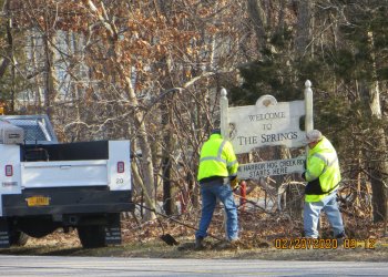 Town workers removing the The Spring sign