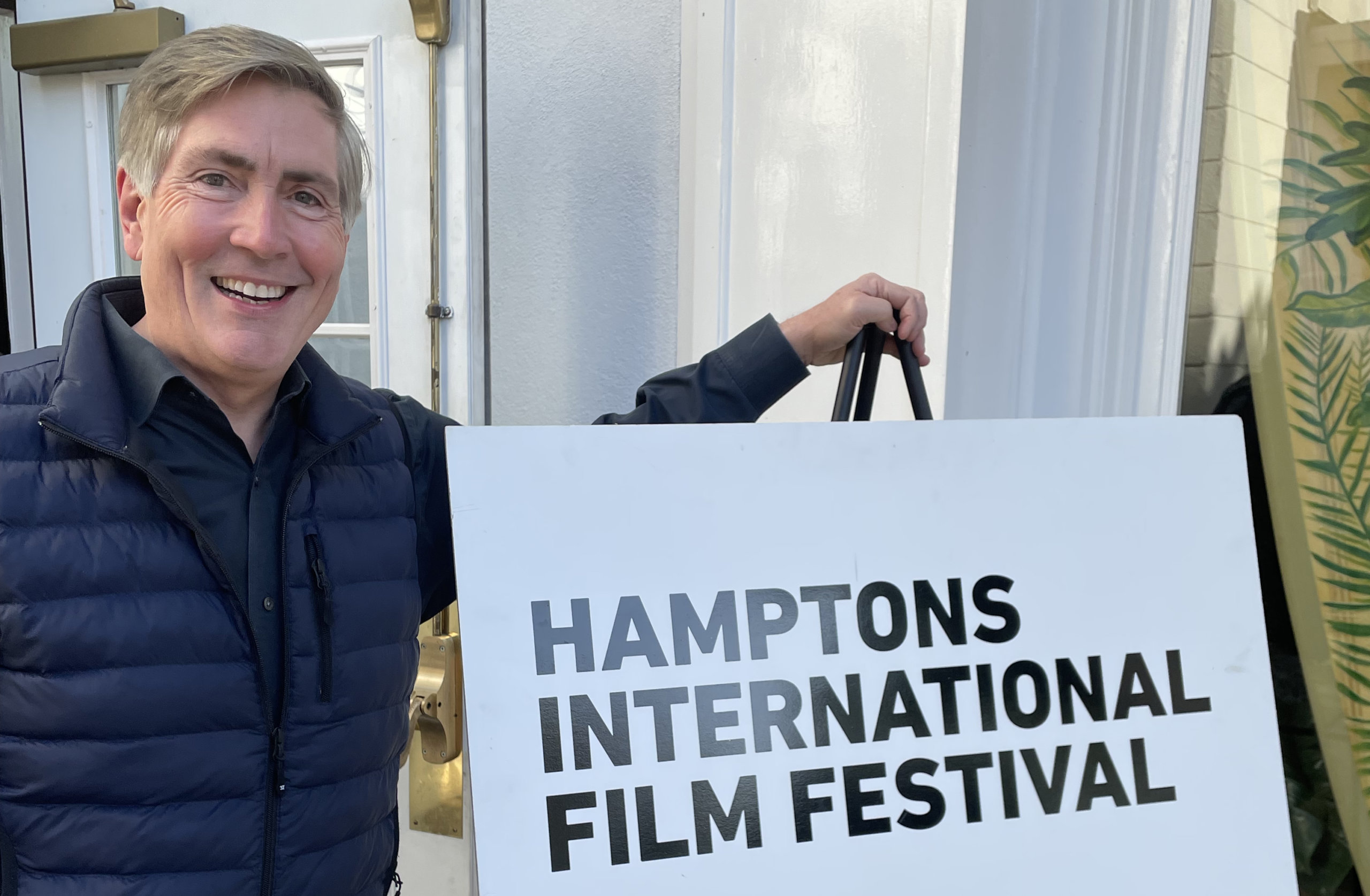 Bill McCuddy in front of HIFF sign, Hamptons International Film Festival