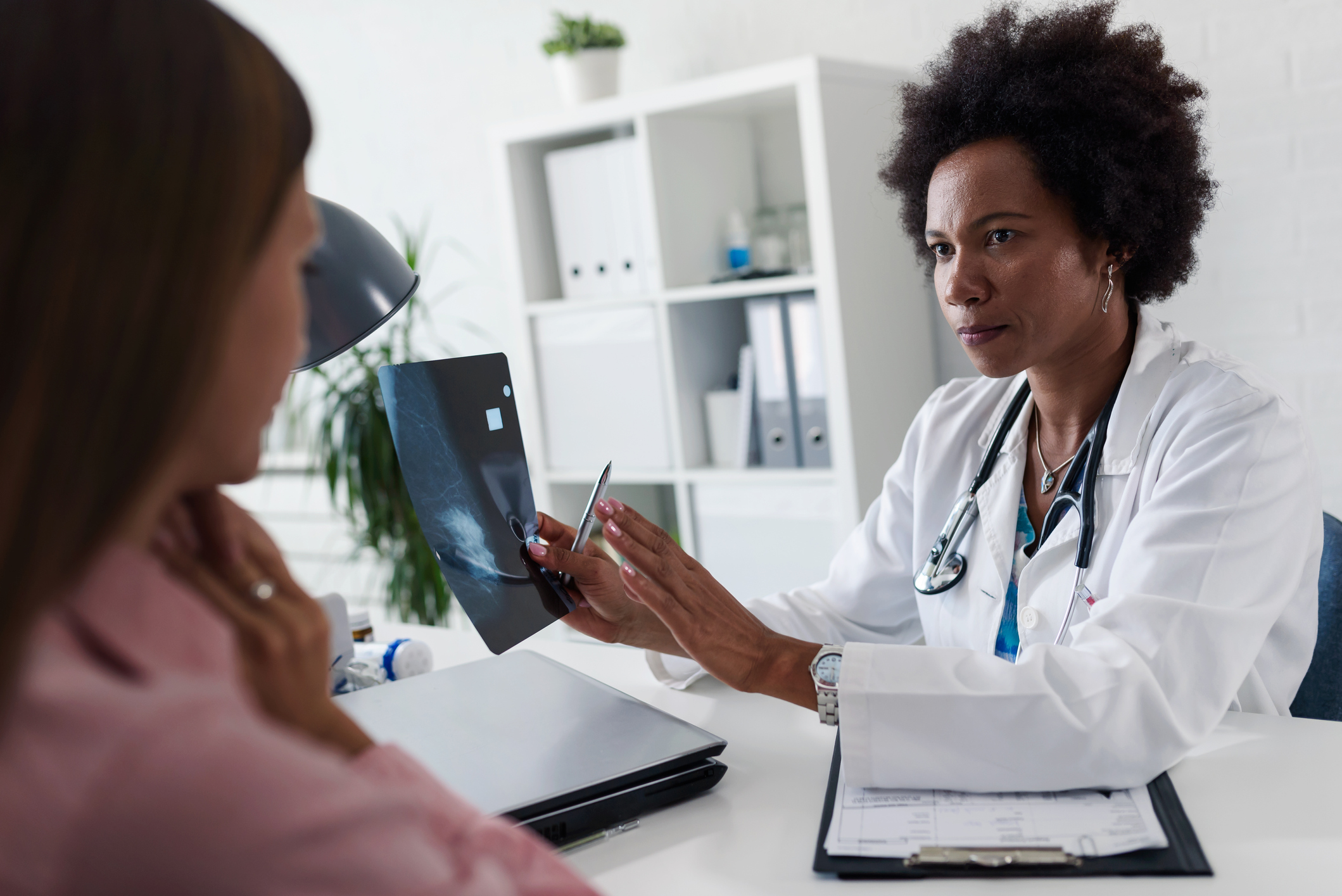 Female doctor looking at mammogram test results of her patient. Breast examination. Mammogram. Health care concept, medical insurance. Womens health.