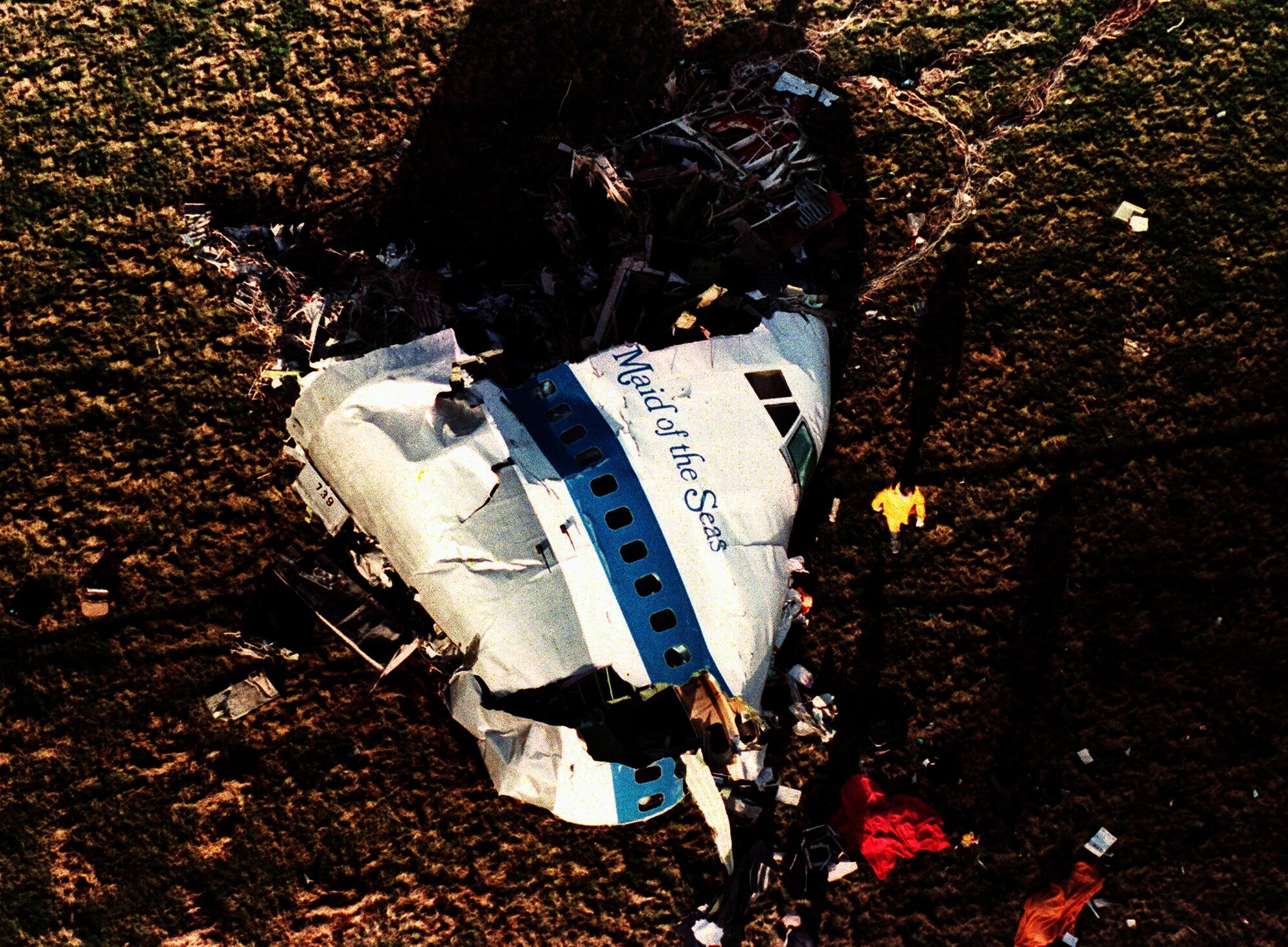 FILE Police and investigators look at what remains of the nose of Pan Am 103 in a field in Lockerbie, Scotland, in this Dec. 22, 1988 file photo. U.S. and Scottish authorities said Sunday, Dec. 11, 2022 that the Libyan man suspected of making the bomb that destroyed a passenger plane over Lockerbie, Scotland, in 1988 is in U.S. custody.