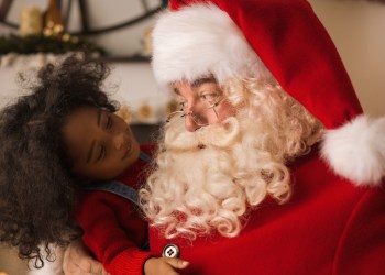 Santa Claus playing with cute African American child at home