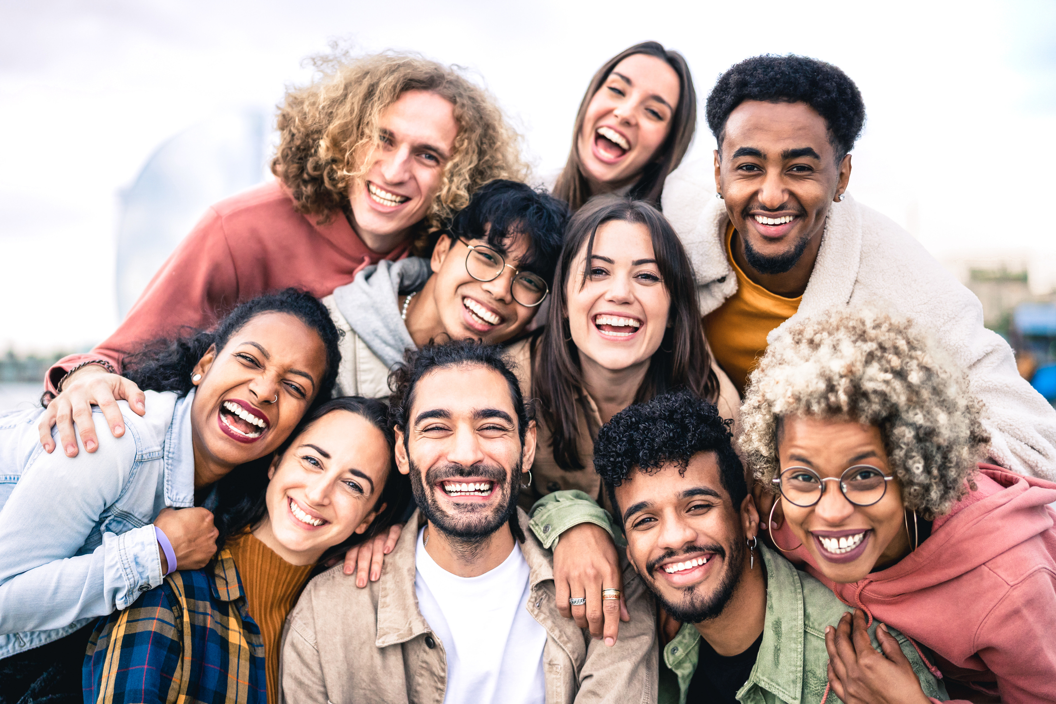 Multi ethnic guys and girls taking selfie outdoors with backlight - Happy life style friendship concept on young multicultural people having fun day together in Barcelona - Bright vivid filter