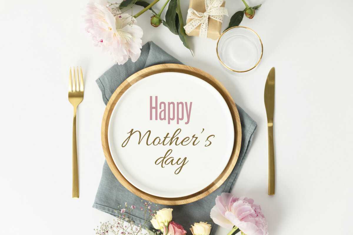 Happy Mother's day concept. Beautiful table setting with golden cutlery and peony flowers, flat lay