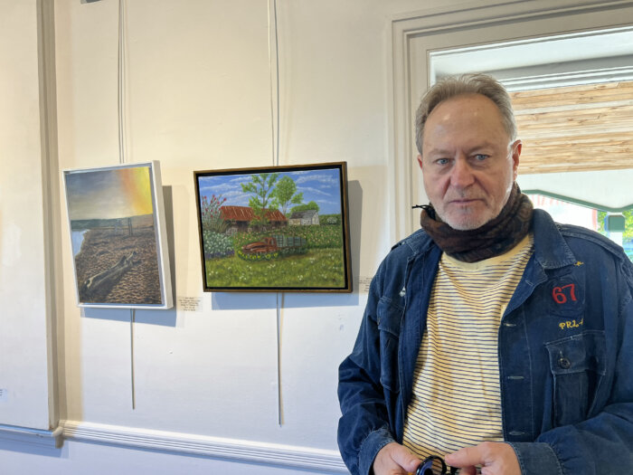 John Melillo with his paintings at an East End Arts member show