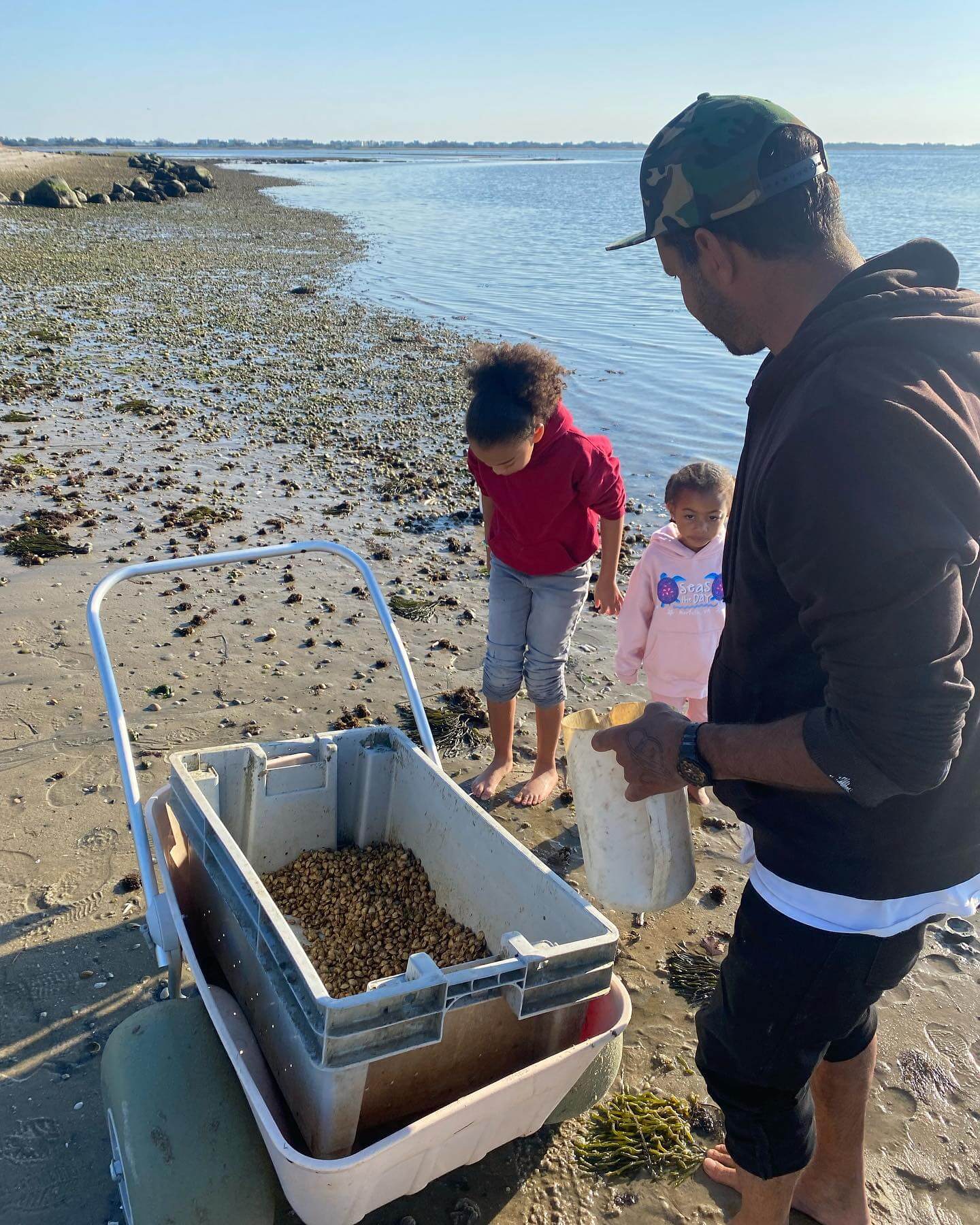 Hatchery worker Mila McKey seeding oysters in Shinnecock Bay with the help of youth from the Boys and Girls Club of Shinnecock