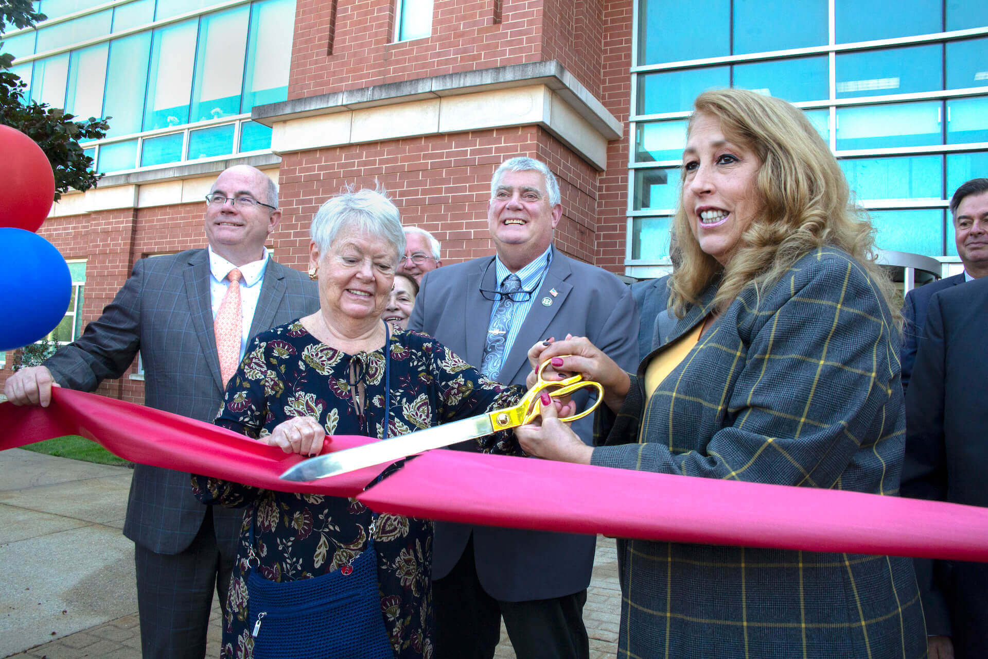 Riverhead Town Supervisor Yvette Aguiar cuts the ribbon with help from Peconic Bay Medical Center Foundation Chairperson Emilie Roy Corey, while Councilmen Kenneth Rothwell, left, and Tim Hubbard, center, look on. Bruce Mermelstein