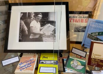 A photo of a young Dan Rattiner and copies of his published books and other Dan's Papers related media on display at Stony Brook Southampton Library