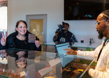 A happy customer makes the first sale at Little Beach Harvest cannabis dispensary. (Tyus Gholson - Scape Imagery, LLC)