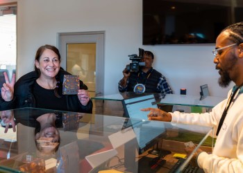 A happy customer makes the first sale at Little Beach Harvest cannabis dispensary. (Tyus Gholson - Scape Imagery, LLC)