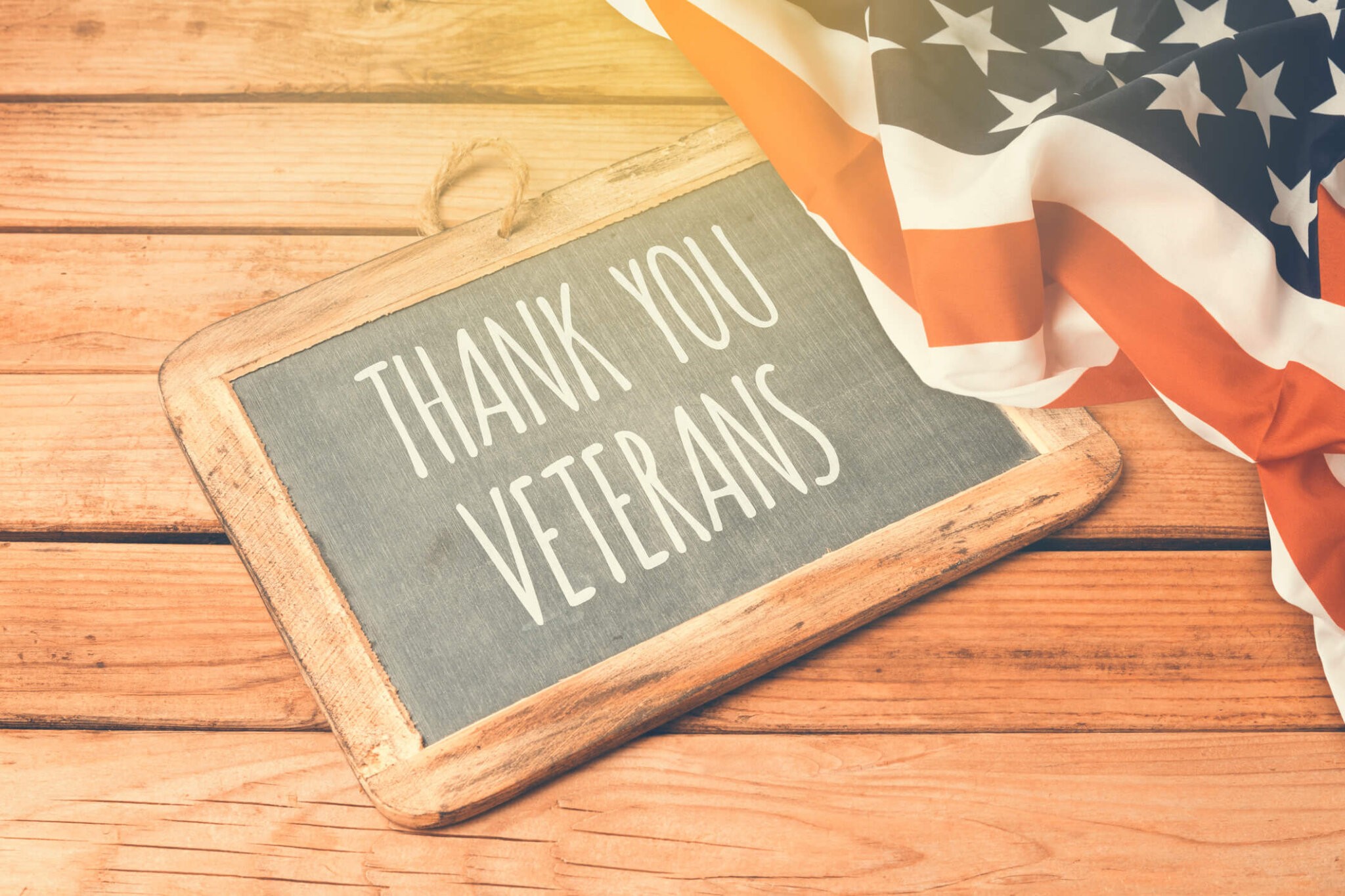 Veterans day background with chalkboard on wooden table and USA flag