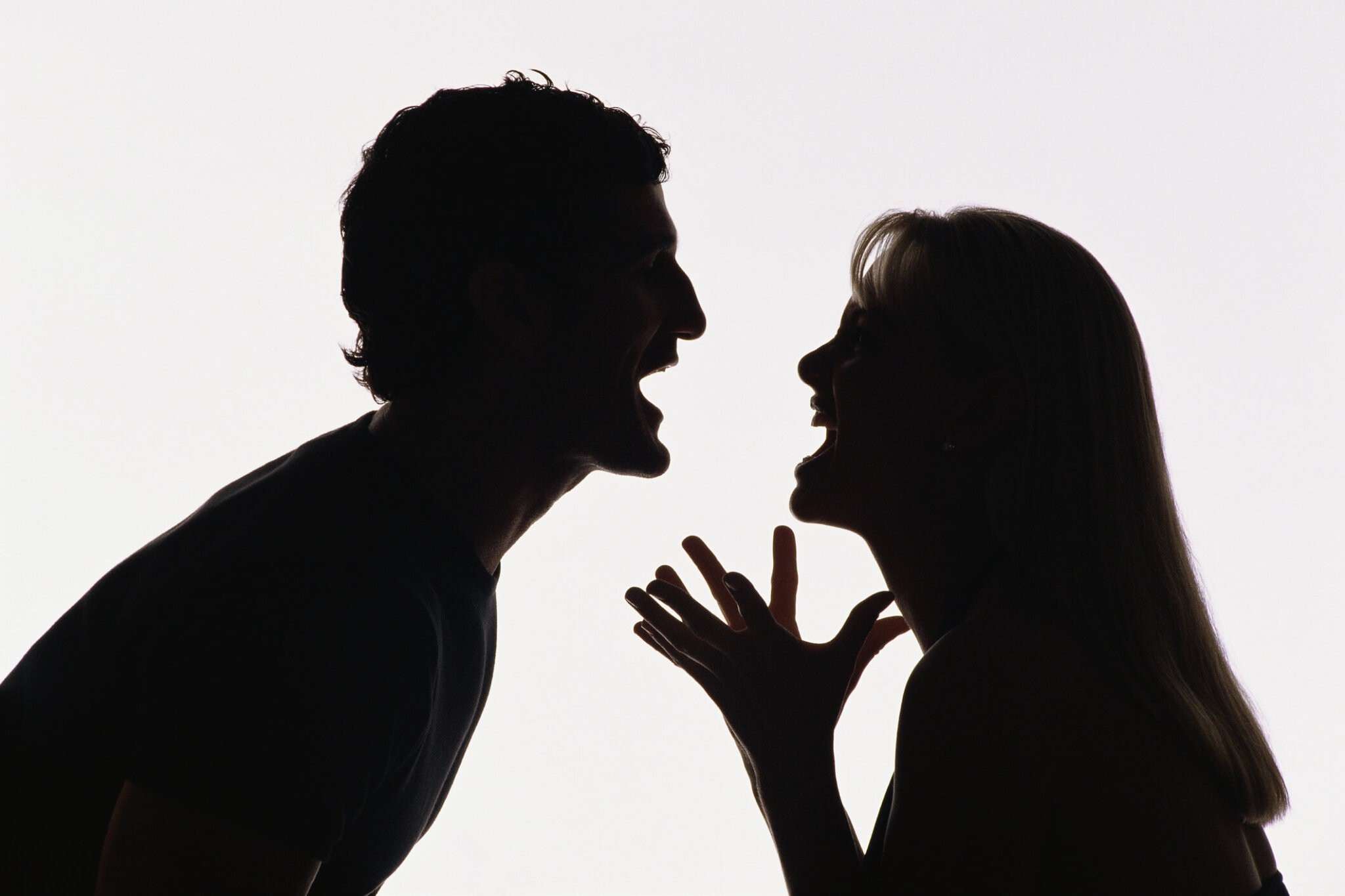 Silhouette of man and woman yelling at each other