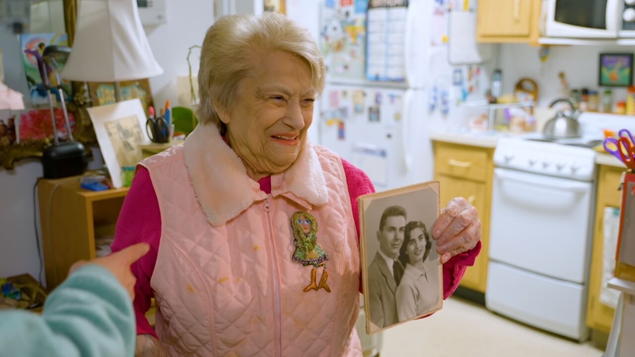 "I Am Judit" Holocaust survivor Judy Sleedwill holding photo of hubby