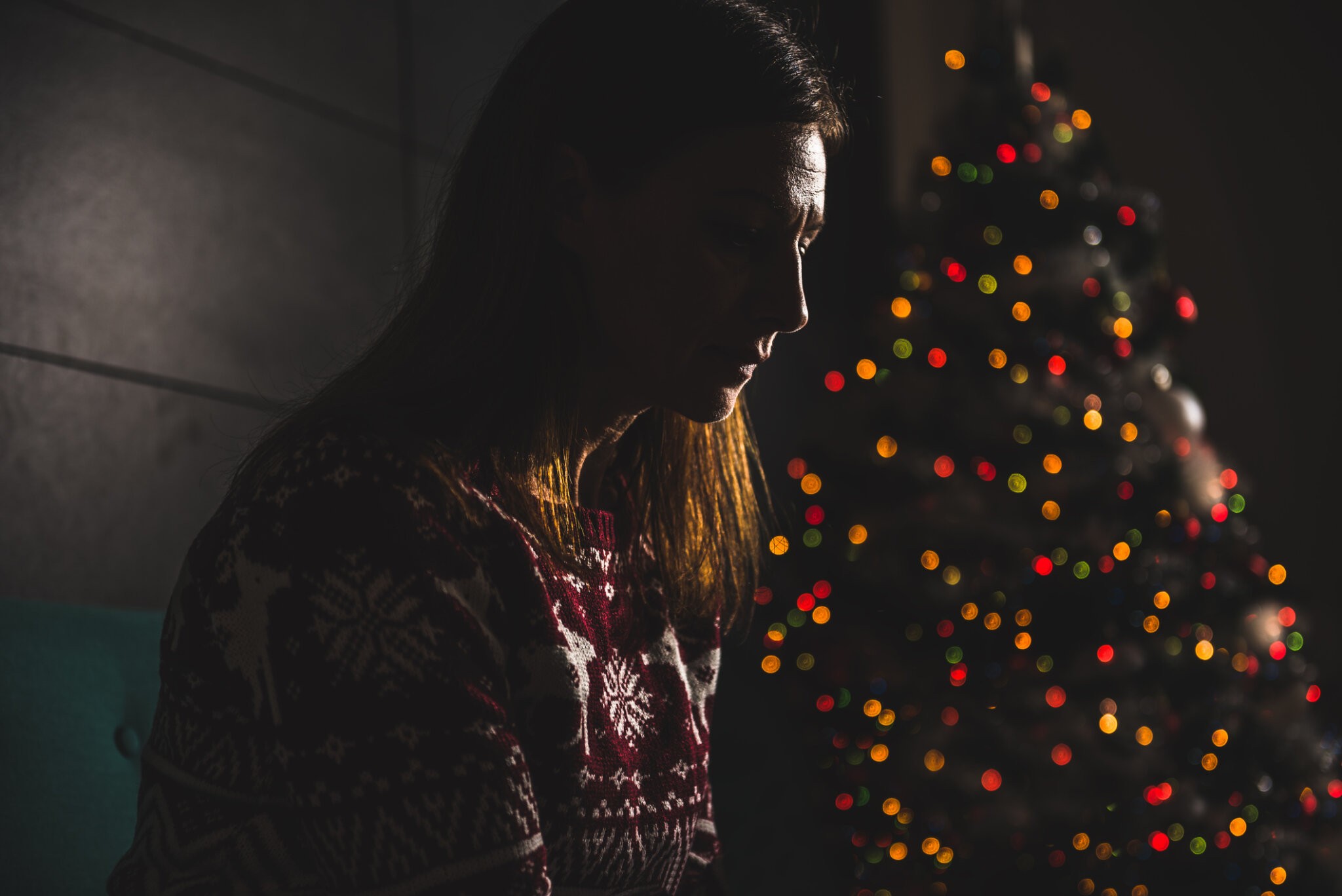 Lonely women sitting on the the sofa at home during christmas holiday