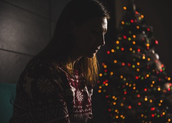 Lonely women sitting on the the sofa at home during christmas holiday