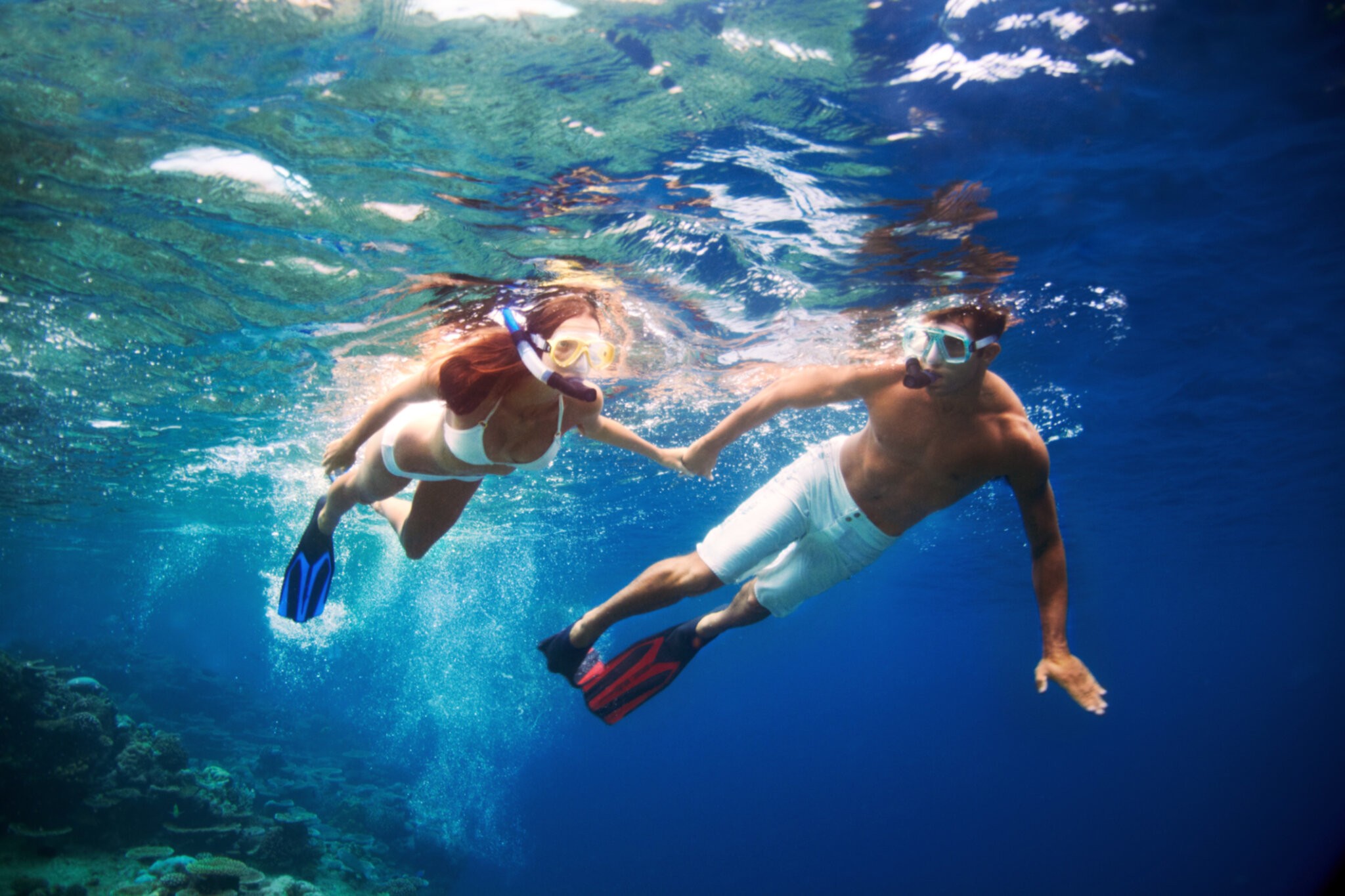 A young couple enjoying snorkeling in the turquiose water of the sea Palm Beach