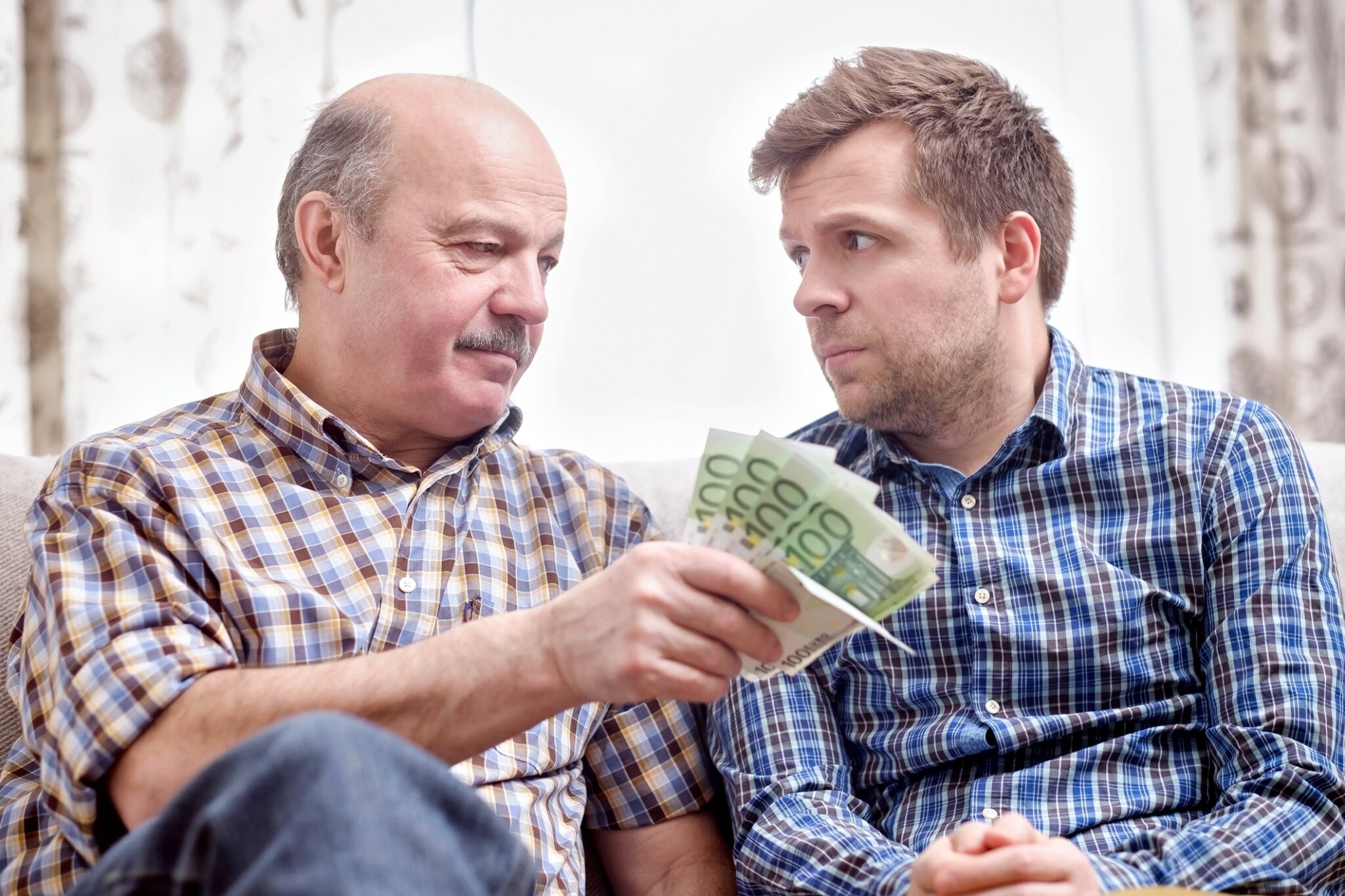 Elderly father lends money to his adult child son. He helps his child deal with financial problems.
