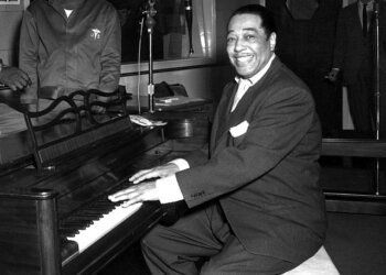 Duke Ellington, a famous jazz musician, poses with his piano at the KFG Radio Studio. KFG is Fitzsimons Army Medical Center's radio station