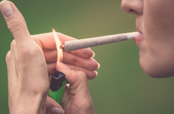 Close-up of woman smoking marijuana cannabis joint 420 pot