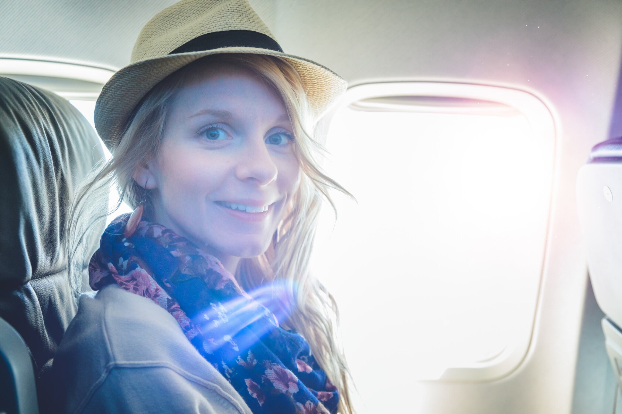 Young Woman Alone Looking Looking at the Camera inside Airplane While Going in Vacation