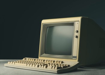 Vintage personal computer with keyboard on a desktop, outdated electronics concept