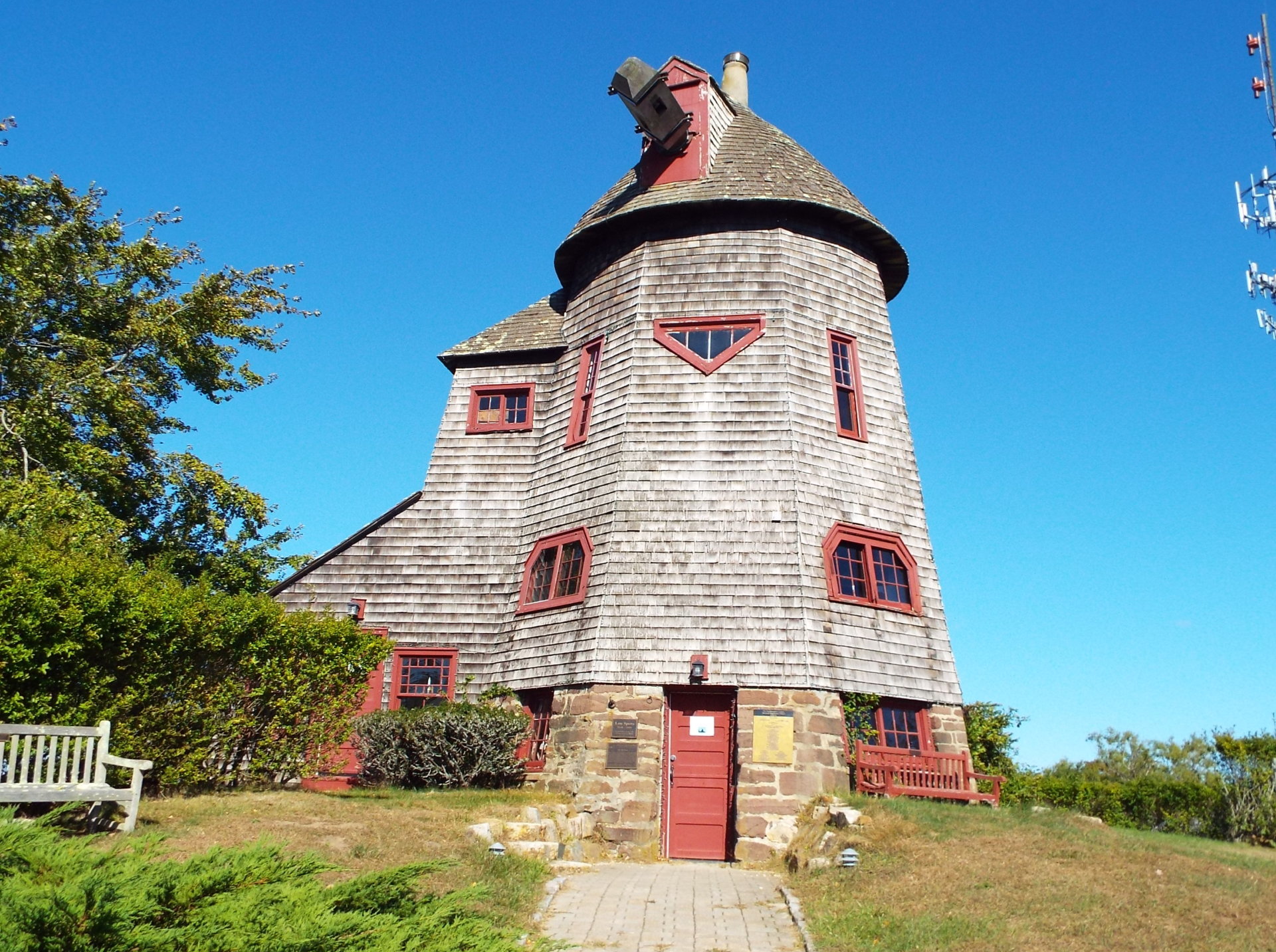 The windmill at Stony Brook University's Southampton campus. A sign on the door reads: "Please pardon our appearance while we build new vanes for the windmill."