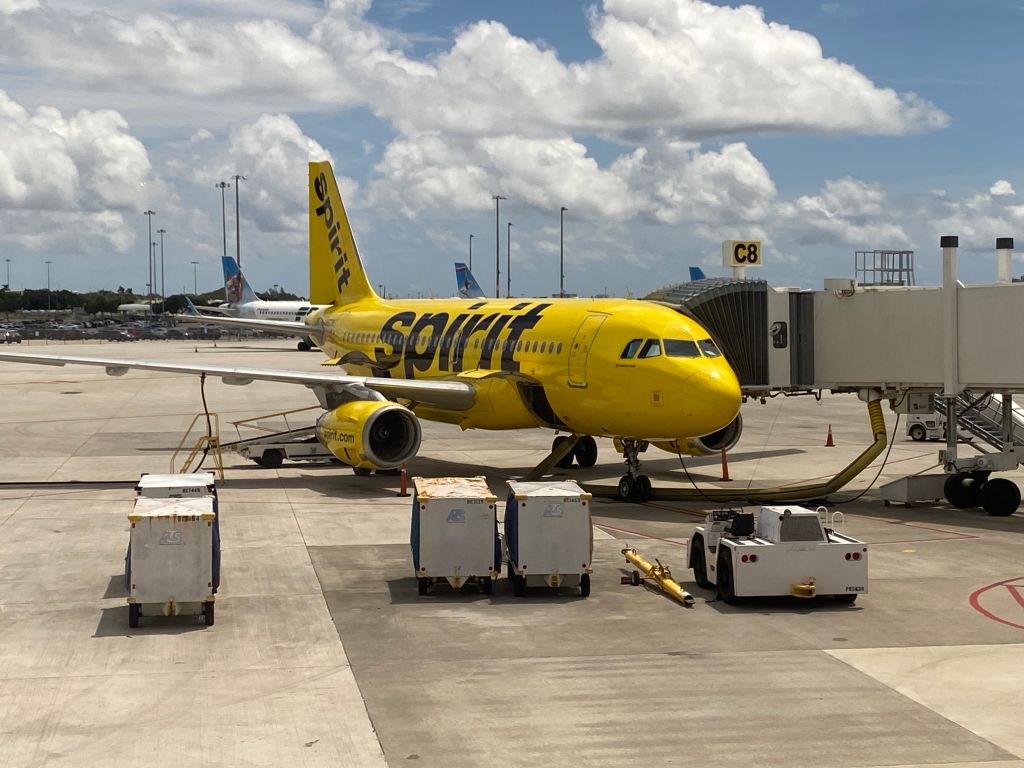 Spirit Airlines plane parked at gate waiting for baggage unloading, Palm Beach International Airport, Florida