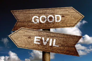 Good Or Evil concept road sign with blue sky background.