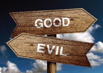 Good Or Evil concept road sign with blue sky background.