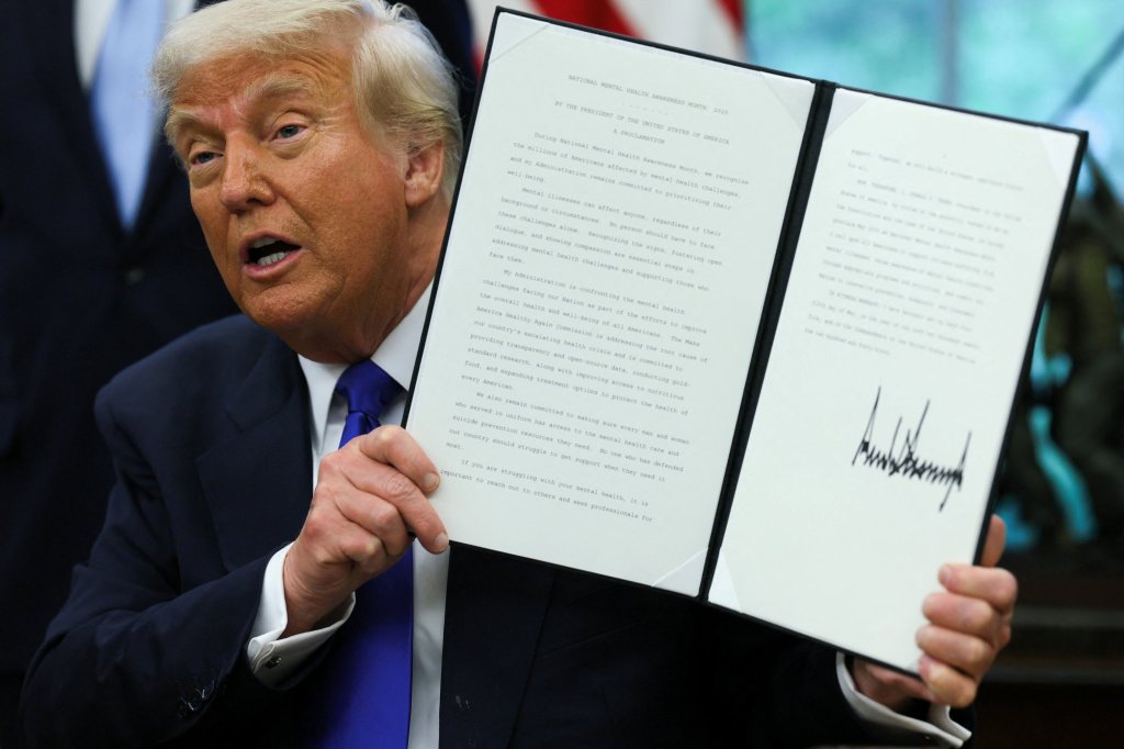 U.S. President Donald Trump holds a signed proclamation as he signs executive orders and proclamations in the Oval Office at the White House, in Washington, D.C., U.S., May 5, 2025.