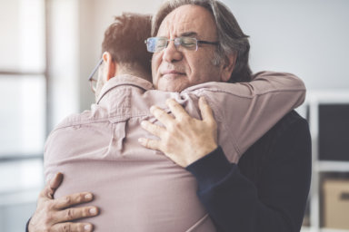 Son hugs his own father showing relational love