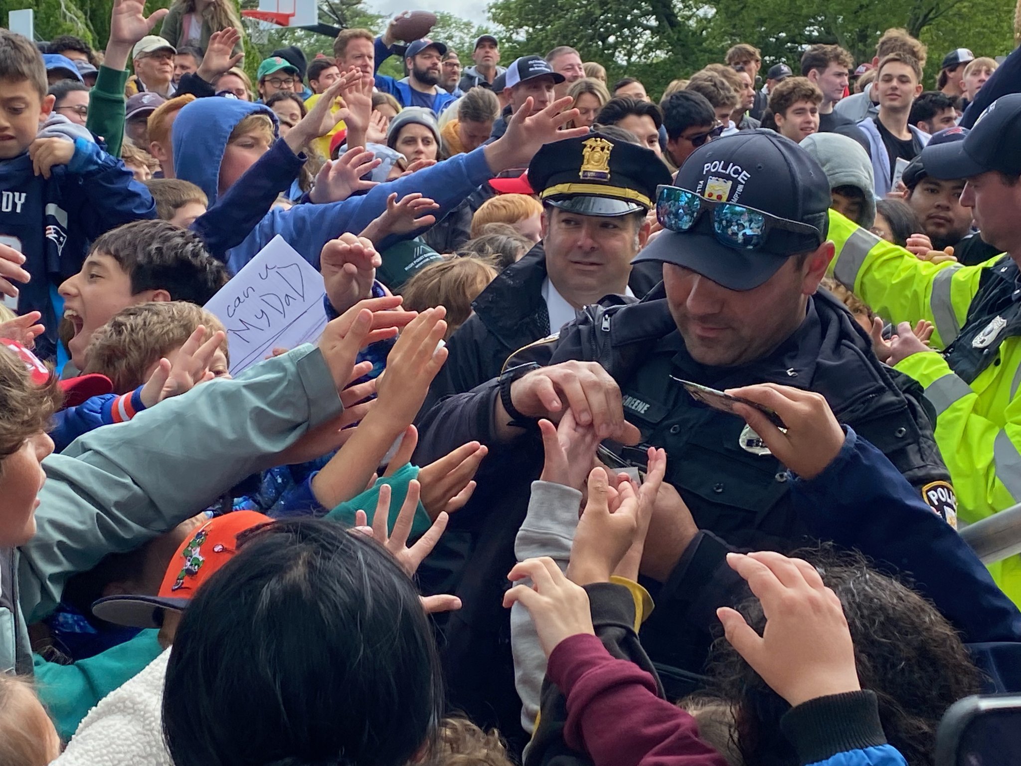 Police hand out cards to rabid fans at the CardVault by Tom Brady opening in East Hampton