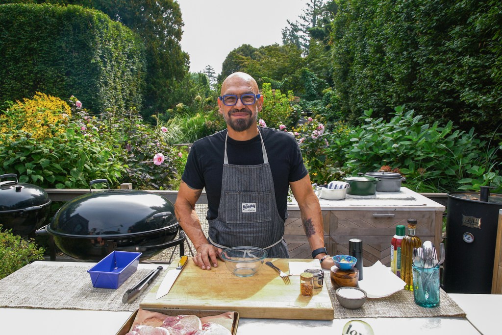 Host Michael Symon on set to make Fennel Crusted Pork Porterhouse with Citrus Salad, Stuffed Hot Peppers, Grilled Broccoli Rabe with Pancetta, and Smoky Bourbon Soursas seen on Food Network's Symon's Dinners Cooking Out, Season 5.
