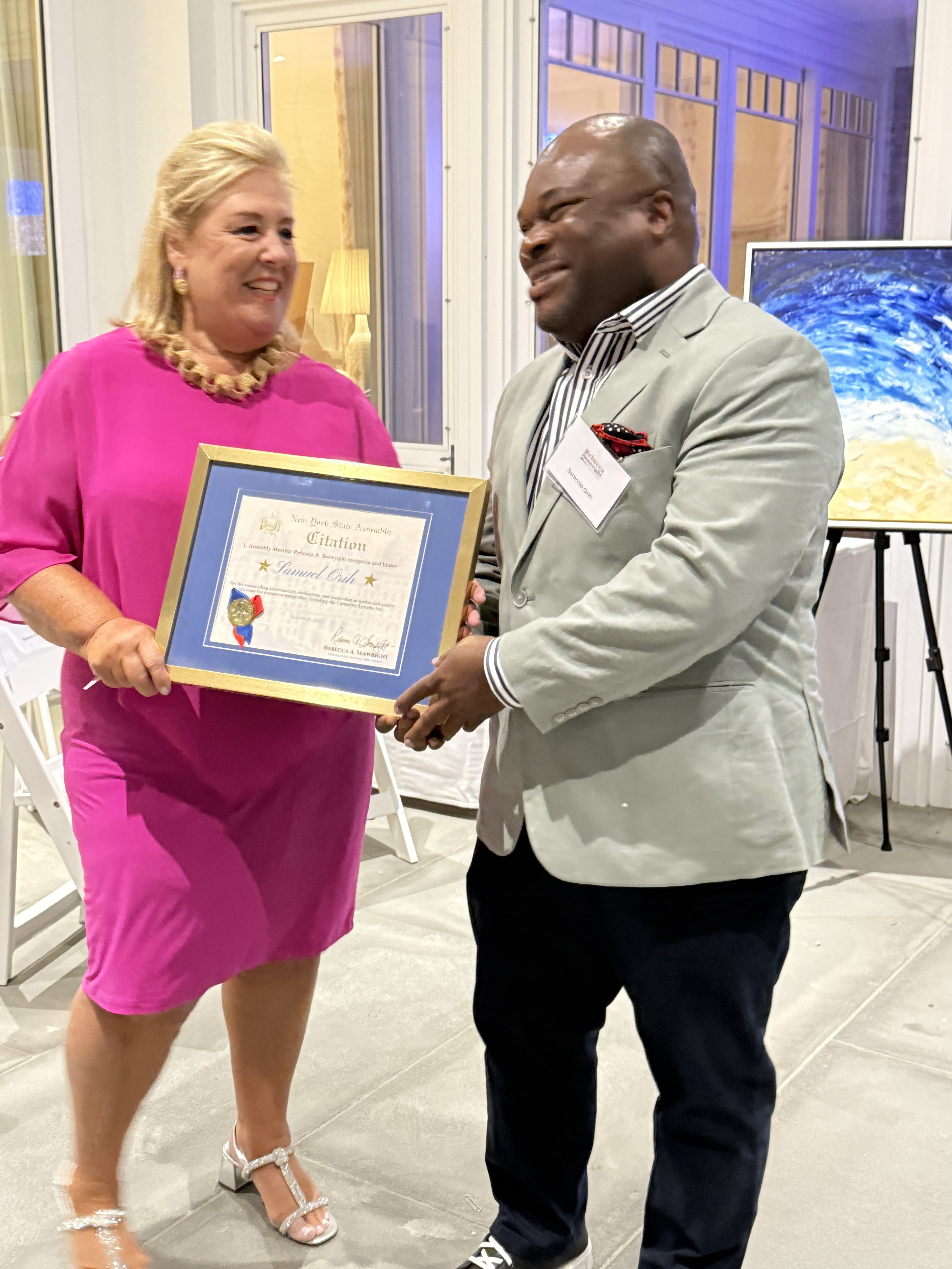 Sammie Orih surprised with an award by Assemblywoman Rebecca Seawright