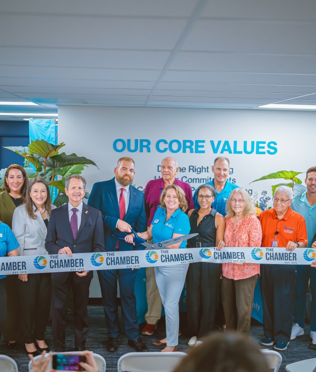 Habitat GPBC staff, board, and supporters cut the ribbon at the new office with Michael Zeff,