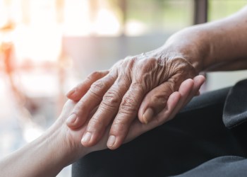 A caregiver reaches out to a patient with Parkinson's disease. (Getty Images)