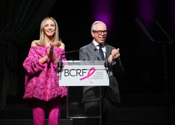 Dee Ocleppo Hilfiger and Tommy Hilfiger speak onstage at the Breast Cancer Research Foundation New York Symposium and Awards Luncheon at New York Hilton Midtown.