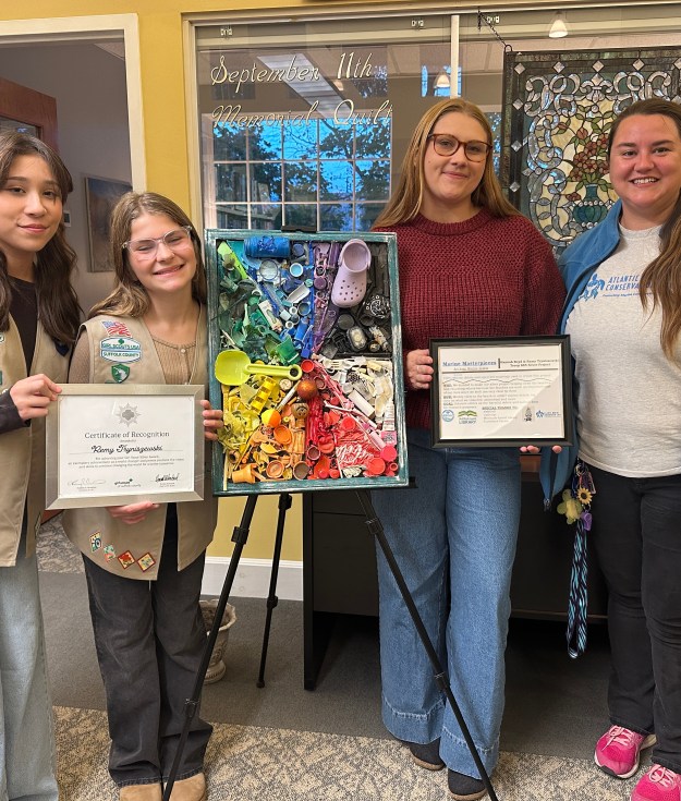 (L to R) Girl Scouts Remy Tryniszewski and Hannah Boyd with Bri Sander and Ellie Sywak of AMSEAS (Atlantic Marine Conservation Society) at the Mattituck-Laurel Library unveiling the Silver Award Project