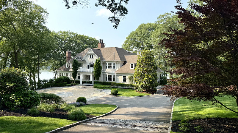 Waterfront Hamptons style house photo, and one below it with the porch, showing the water and dock or town of Huntington